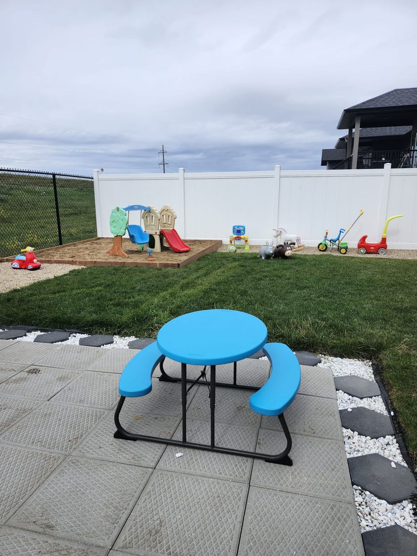Fenced outdoor play area with ride-on toys